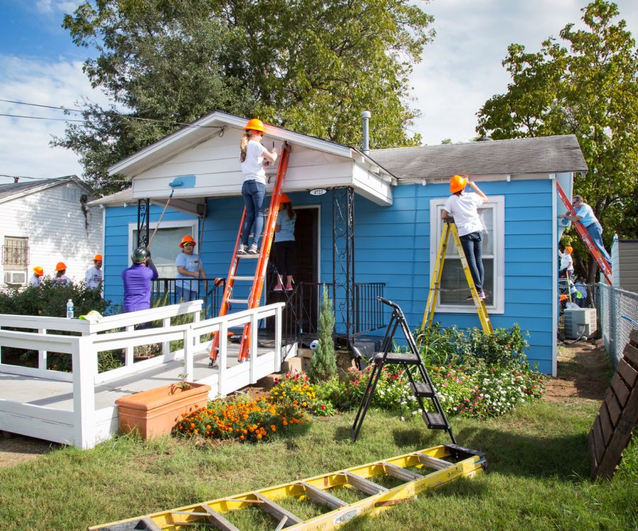 volunteers painting the exterior of a house