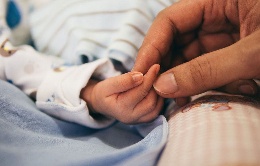 close up shot of a parent holding a newborn hand