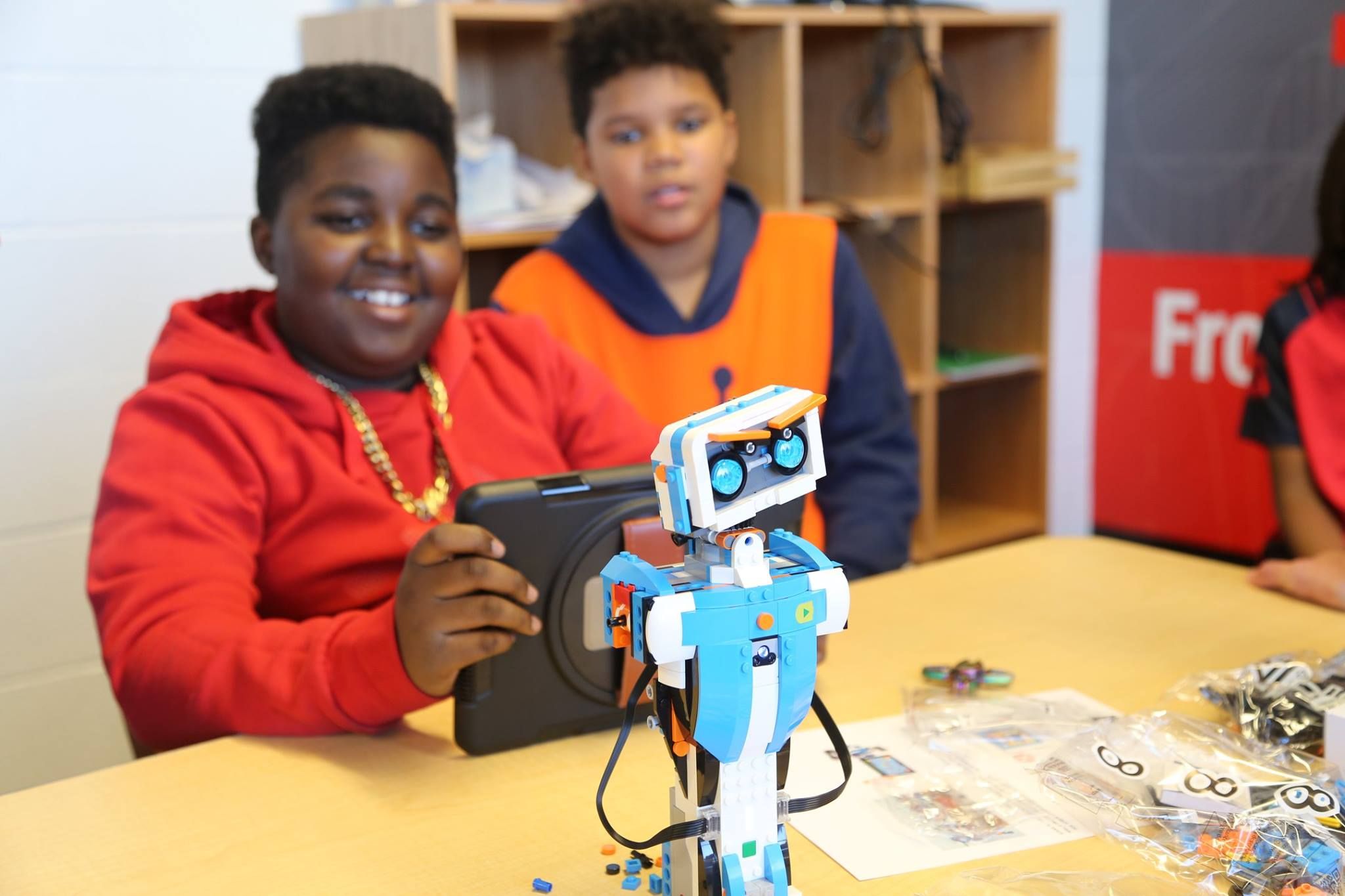 two boys playing with a robot