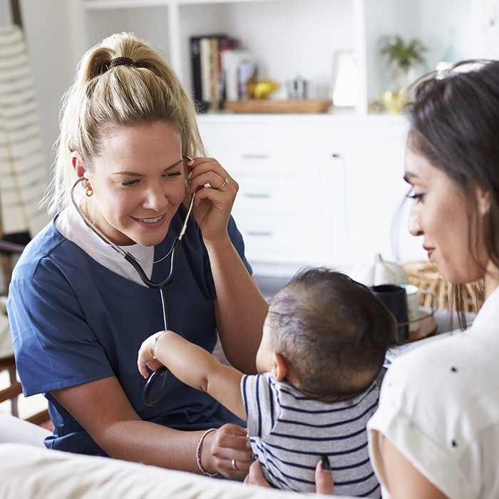 nurse checks newborn vitals as mom watches