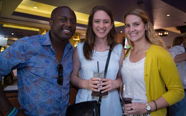 three young adults with drinks smile