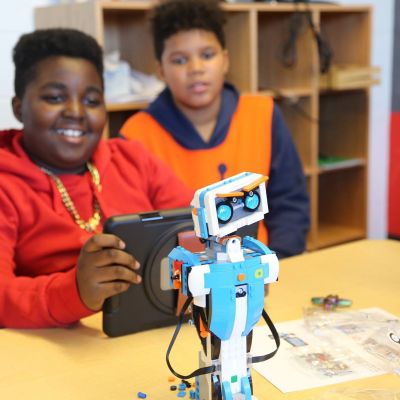 two boys playing with a robot